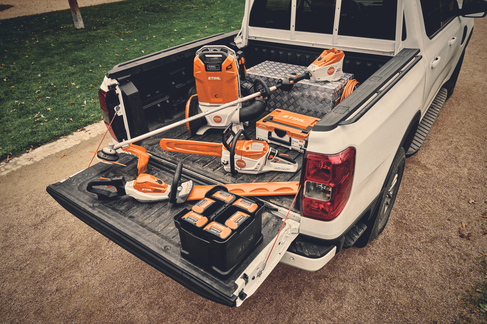 Olika batteridrivna maskiner och passande batterier från STIHL AP-System på ett fordonsflak  