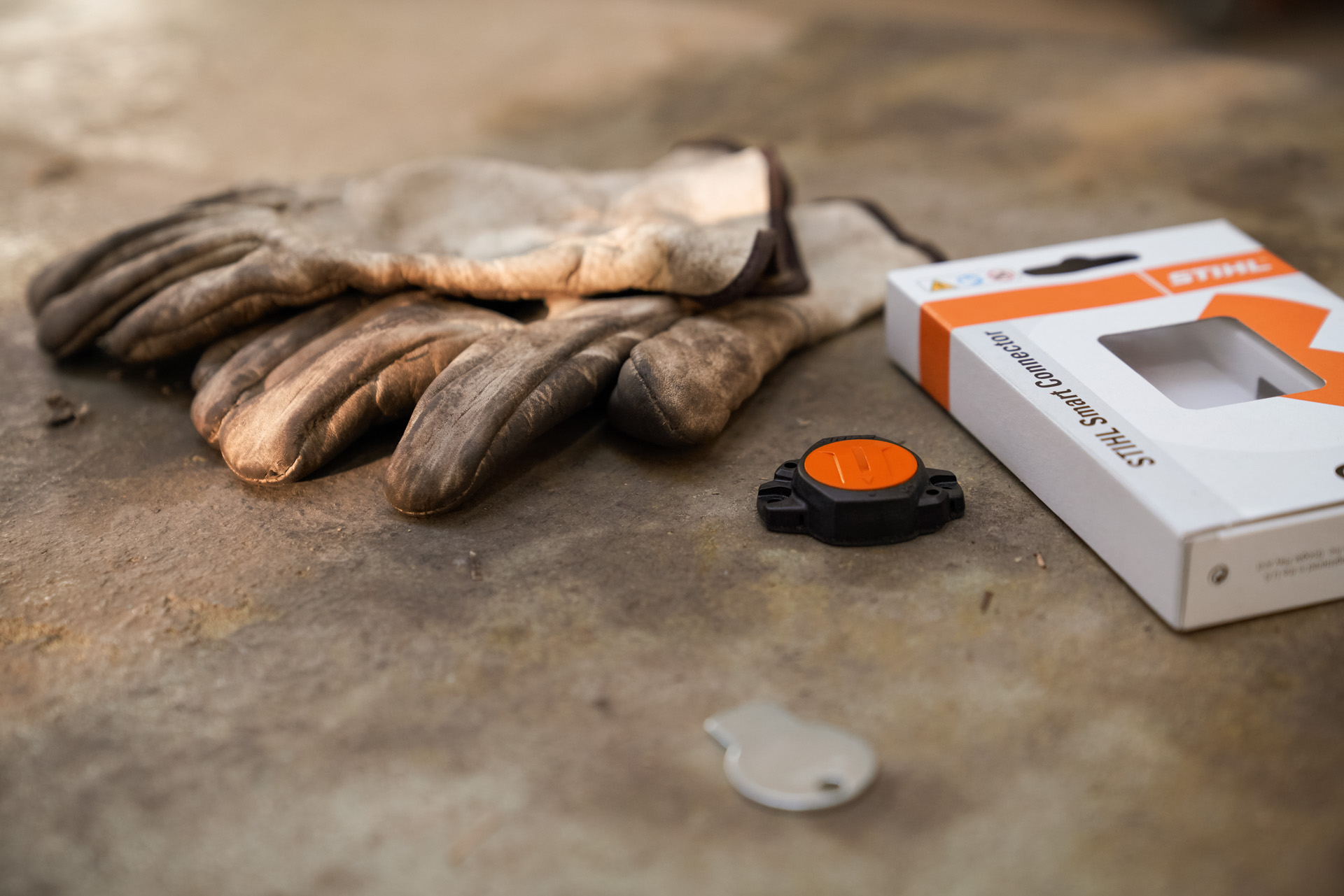 En STIHL Smart Connector bredvid tillhörande förpackning.