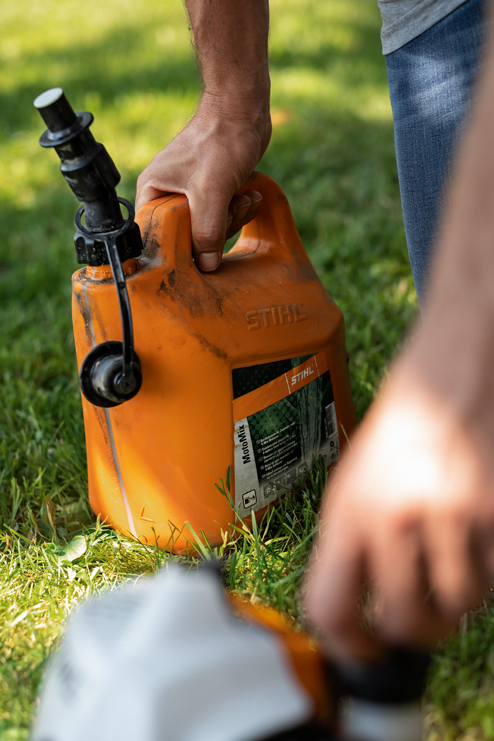 Bränslet STIHL MotoMix för trimmern i den orange behållaren