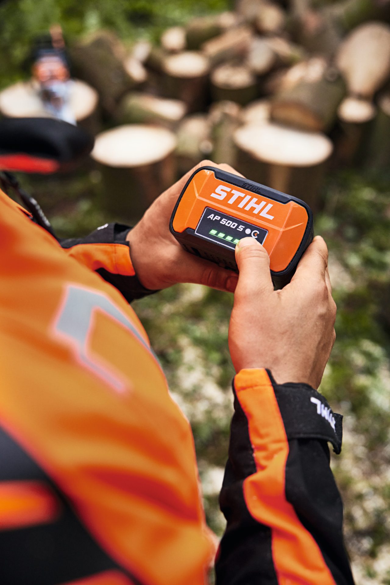 Närbild av en person som kapar en trädstam med en STIHL MSA 300 batteridriven motorsåg