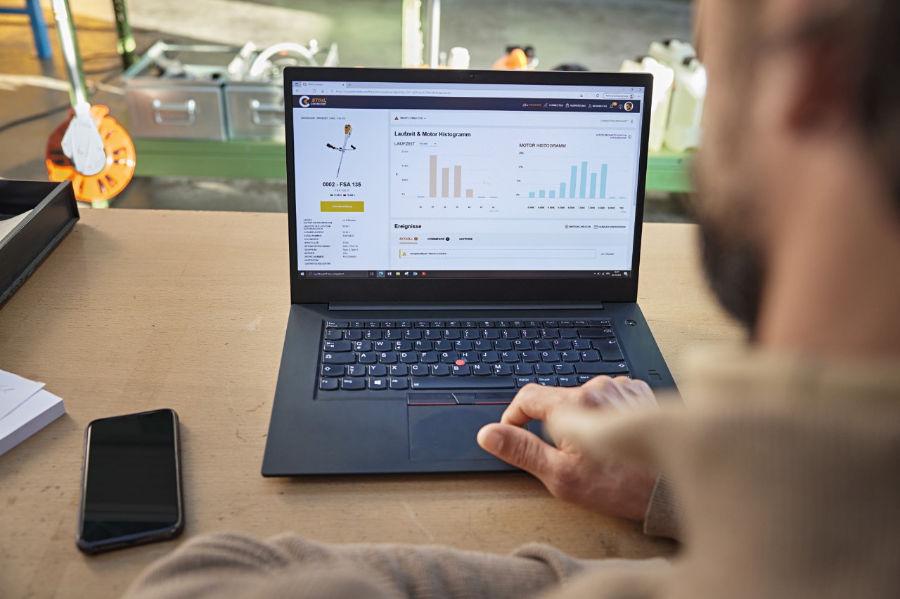 En person som använder STIHL connected-portalen på en bärbar dator för att visa olika maskindata. 