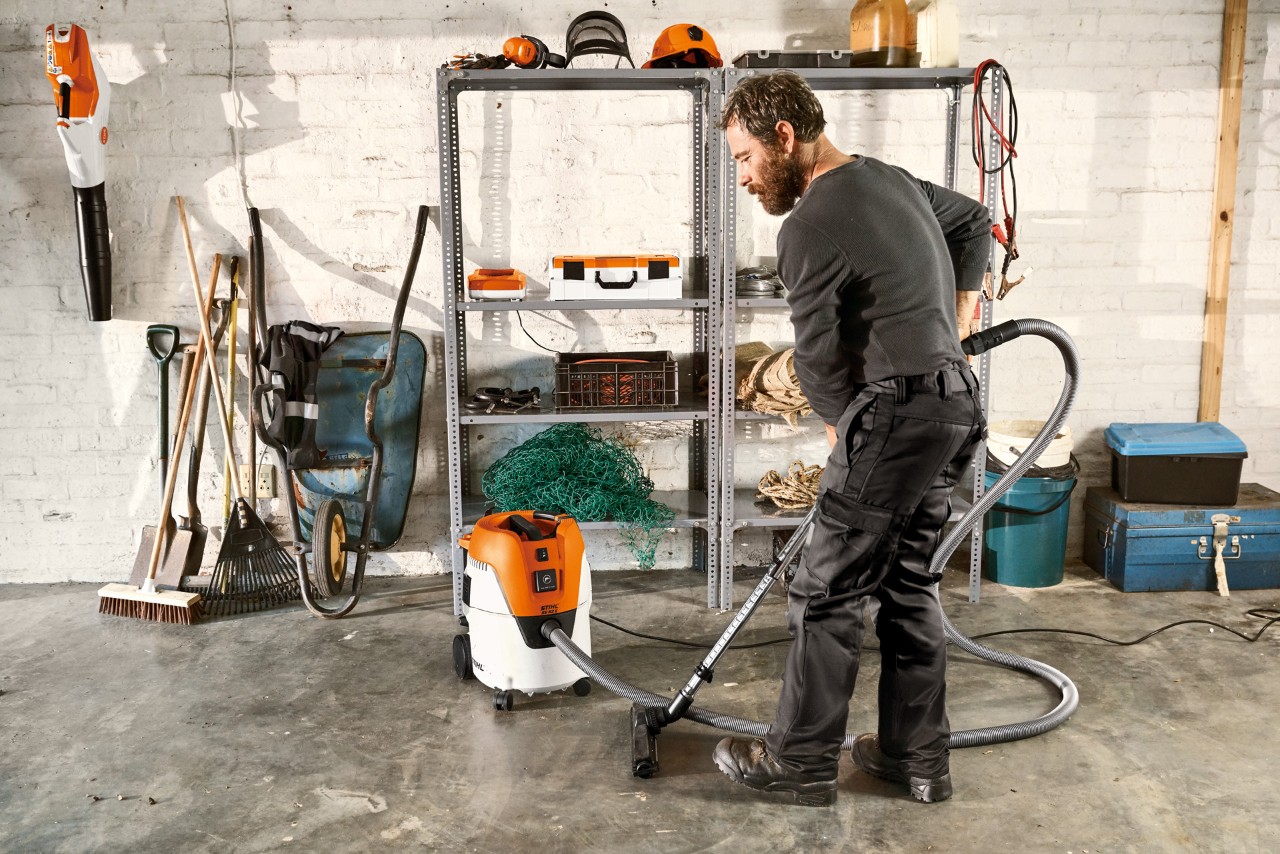 Man dammsuger garagegolvet med en STIHL SE 62 E våt-/torrdammsugare