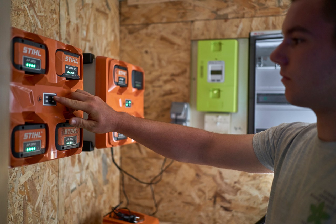 En man som står vid en batteriladdningsstation