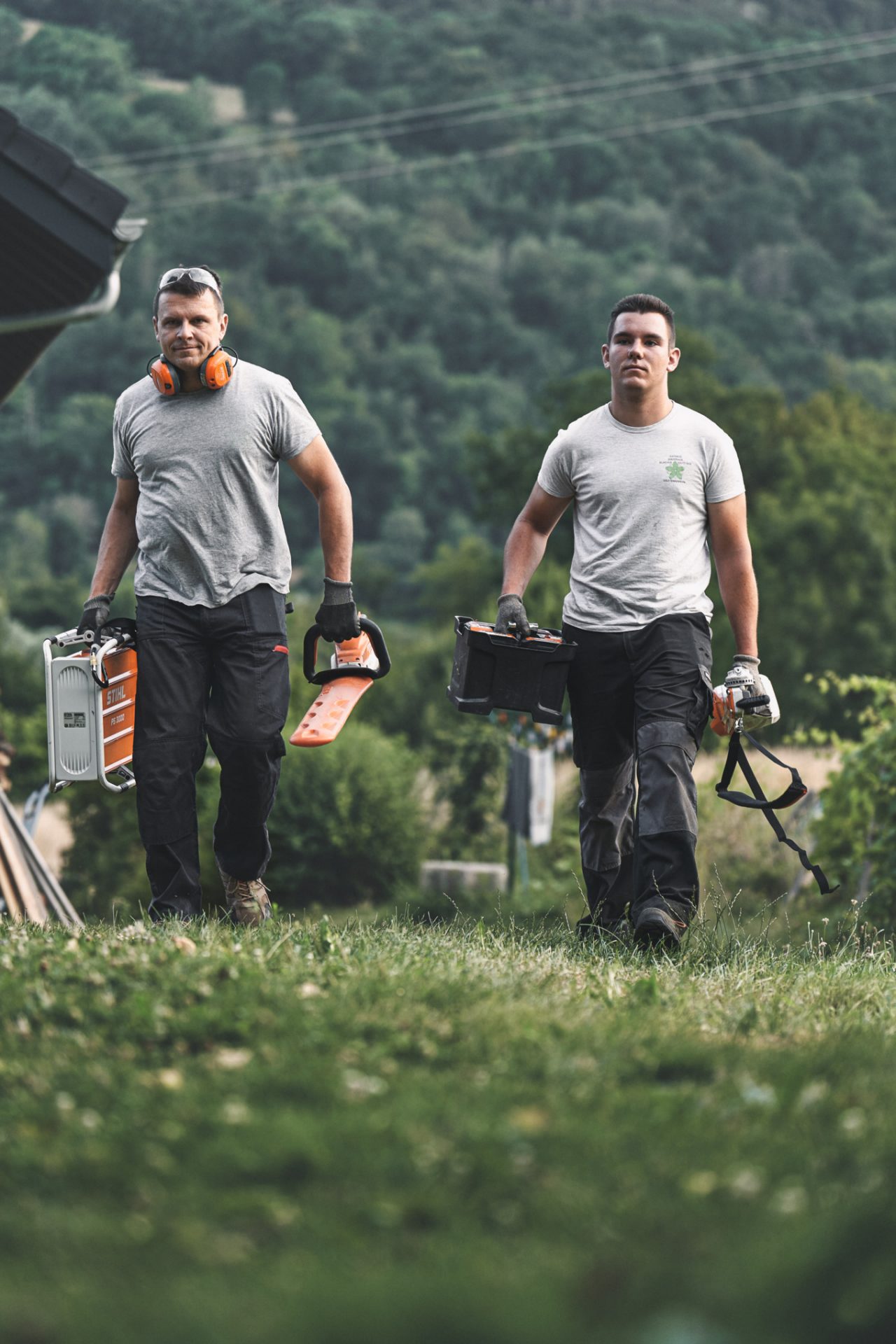 Två proffs går genom ett fält med STIHL batteridrivna maskiner