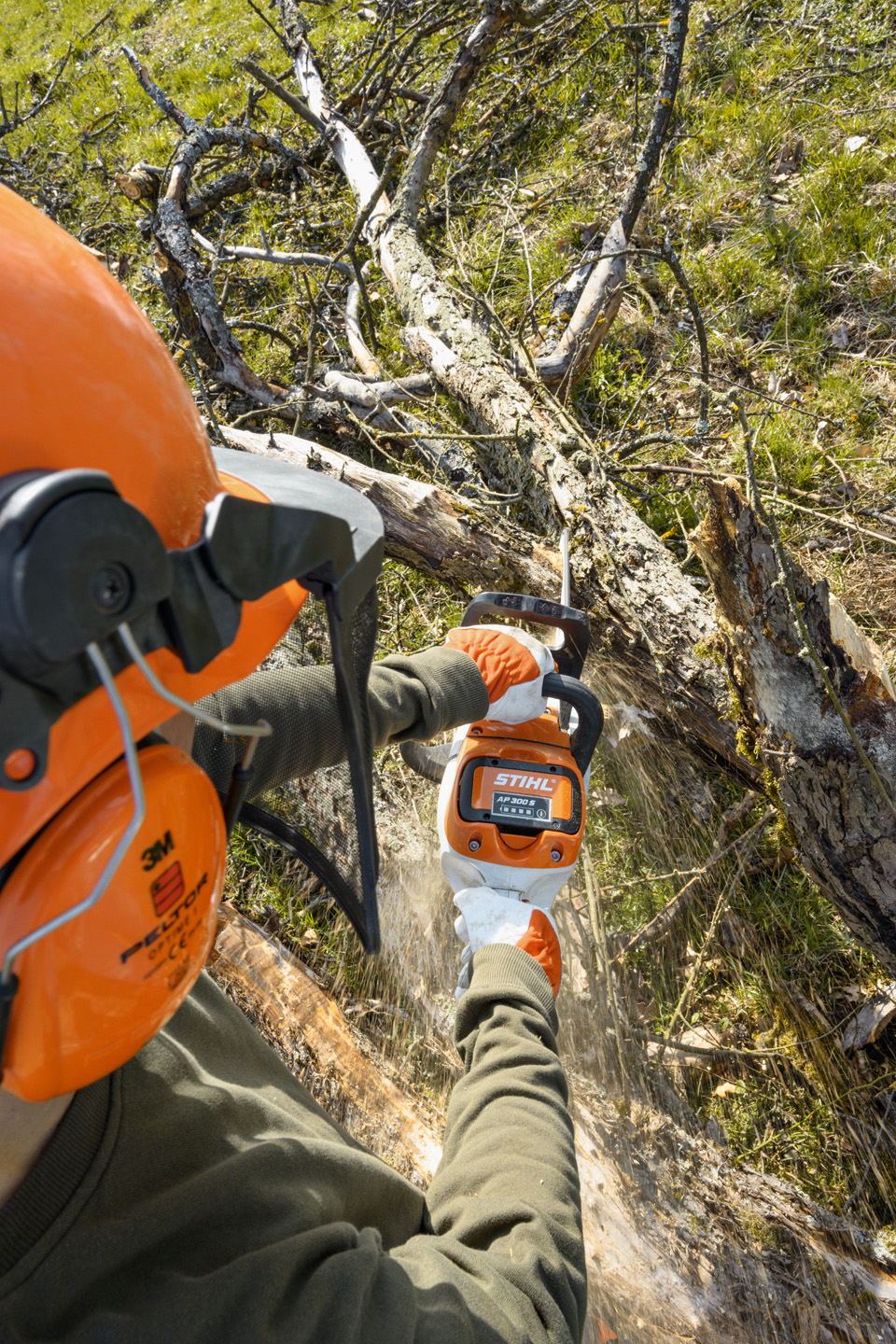 STIHL MSA 220 C-B batteridriven motorsåg används på en trädstam med grenar