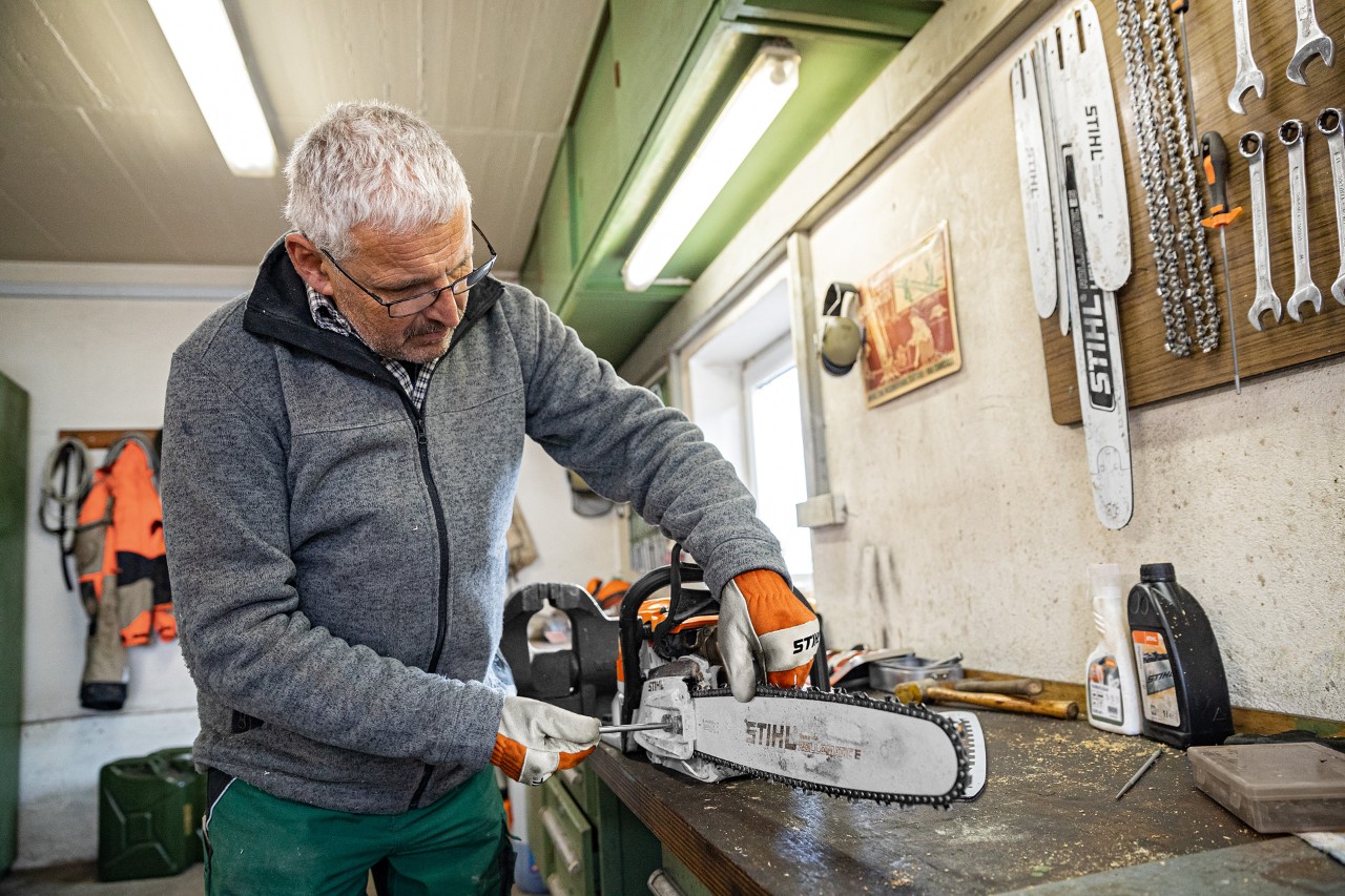 En man spänner en motorsågskedja kedjan på en STIHL motorsåg