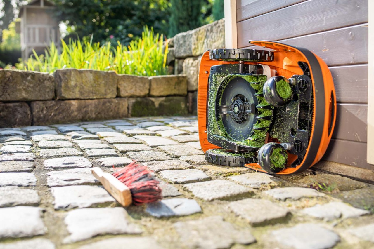 STIHL iMOW® robotgräsklippare tippad på sidan redo för rengöring
