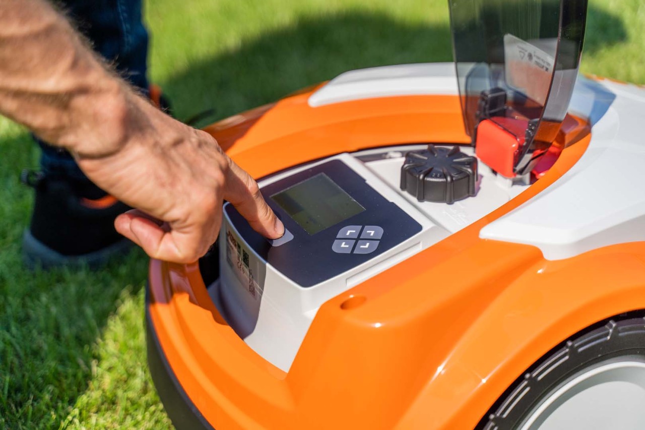 Kontrollpanelen på en STIHL iMOW® 422 robotgräsklippare när någon trycker på en knapp på den