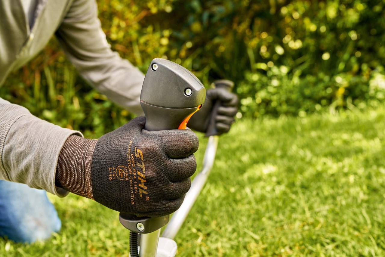 En man låter motorn på STIHL FS 91 bensindriven trimmer starta kort