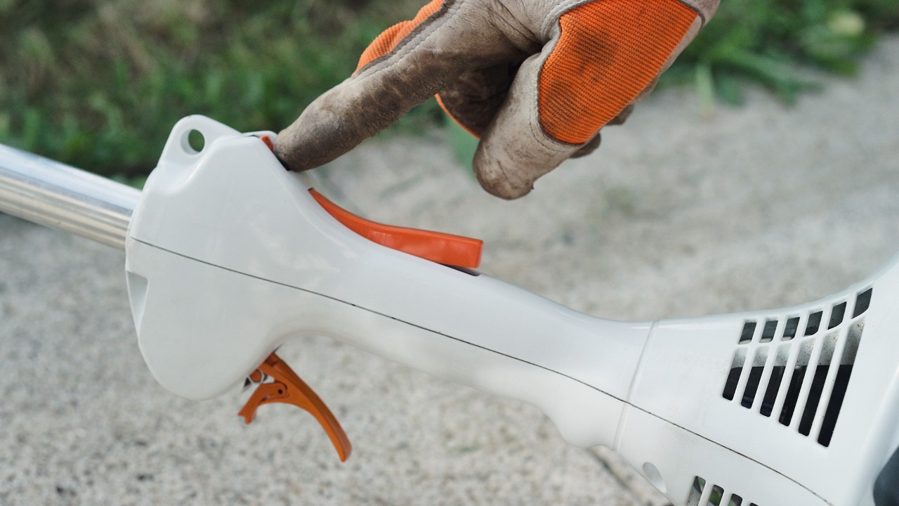 En man aktiverar stoppbrytaren på STIHL FS 38 bensindriven trimmer