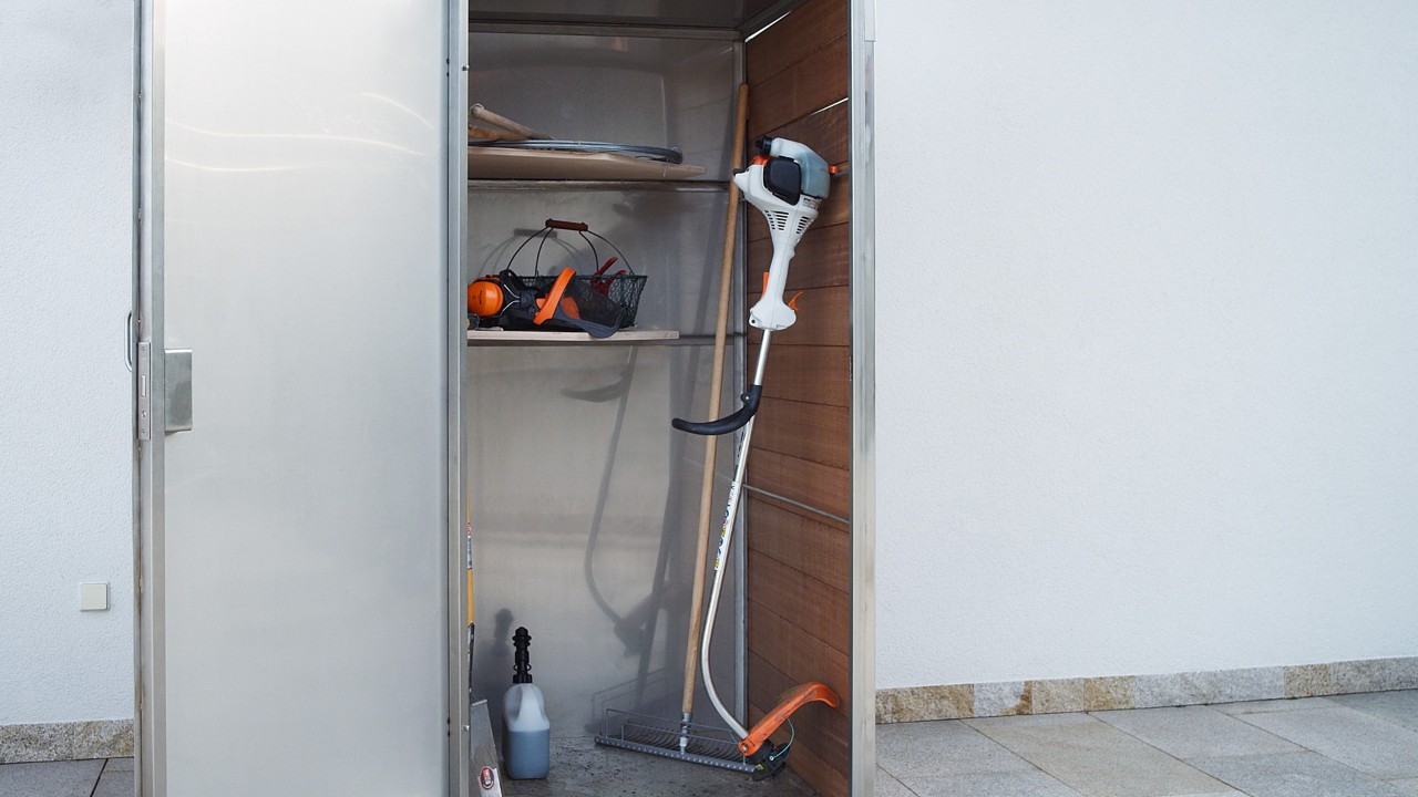 En avstängd STIHL FS 38 bensindriven trimmer står i ett skåp