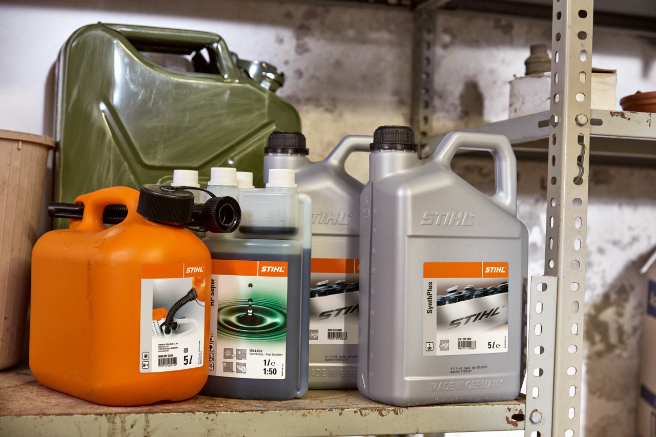 Ljus behållare med STIHL tvåtaktsmotorer HP Super och orange behållare med trimmerblandning